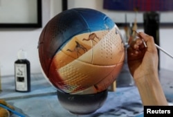 Paraguayan artist Lili Cantero, 29, paints a soccer ball ahead of the 2022 FIFA World Cup, in San Lorenzo, Paraguay October 15, 2022. REUTERS/Cesar Olmedo