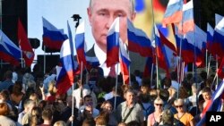 People gather in front of a large screen to celebrate the incorporation of regions of Ukraine into Russia, in Sevastopol, Crimea, Sept. 30, 2022. The signing of the treaties making the four regions part of Russia followed the completion of Kremlin-orchest