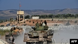 Anggota dari kelompok jihadis Hayat Tahrir al-Sham (HTS) membawa perlengkapan militer milik mereka di pinggiran Kota Afrin, Suriah, pada 13 Oktober 2022. (Foto: AFP/Rami al Sayed)