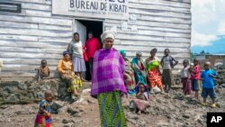 FILE - Pasika Bagerimana stands outside a temporary shelter she shares with others who fled fighting, in Nyiragongo, Democratic Republic of Congo, Aug. 31, 2022. Increased violence in the DRC is leading to a surge of refugees crossing the border into Uganda.