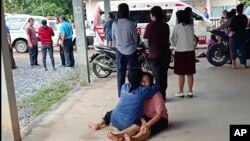 In this image taken from video, a woman is comforted outside the site of an attack at a childcare center, Thursday, Oct. 6, 2022, in the town of Nongbua Lamphu, north eastern Thailand. (Mungkorn Sriboonreung Rescue Group via AP)