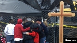 Teman dan kerabat dari sejumlah korban tewas dalam kebakaran di sebuah klub malam di West Warwick, Rhode Island, berkumpul di depan monumen peringatan untuk para korban pada 23 Februari 2003. (Foto: Reuters/Jim Bourg JRB)