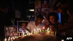 FILE - People hold a candlelight vigil for the victims and injured demonstrators during anti-government protests, in Colombo, July 16, 2022.