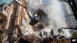FILE - Firefighters work after a drone attack on buildings in Kyiv, Ukraine, Oct. 17, 2022.