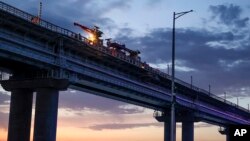 Workers repair the railway part of the Crimean bridge connecting Russian mainland and Crimean Peninsula over the Kerch Strait, Oct. 8, 2022.