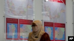 A staff member from Malaysia's Election Commission walks past a map showing state assembly areas at its office in Putrajaya, Malaysia, Oct. 20, 2022.