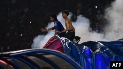 Penonton bereaksi ketika gas air mata dilepaskan oleh polisi setelah pertandingan sepak bola antara Arema FC dan Persebaya di stadion Kanjuruhan di Malang, Jawa Timur. (Foto: AFP)