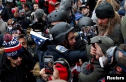 FILE - Pro-Trump protesters clash with DC police officer Michael Fanone at a rally to contest the certification of the 2020 US presidential election results at the U.S. Capitol Building, Jan. 6, 2021.