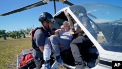 FILE - Members of mediccorps.org help evacuate Tom Acerbo in the aftermath of Hurricane Ian on Pine Island, Fla., Saturday, Oct. 1, 2022.