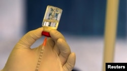 FILE - A health worker prepares to administer the ebola vaccine to a man in Kirembo village, Kasese district, Uganda, June 16, 2019. In an outbreak that began in September 2022 in the country, there have been 60 confirmed cases and 44 deaths, the World Health Organization said.