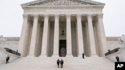 Justice Ketanji Brown Jackson is escorted by Chief Justice of the United States John Roberts following her formal investiture ceremony at the Supreme Court in Washington, Sept. 30, 2022.