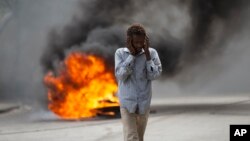 FILE - A man walks past a burning barricade during a protest over the death of journalist Romelo Vilsaint, in Port-au-Prince, Haiti, Oct. 30, 2022. 