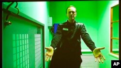 FILE - Russian opposition leader Alexey Navalny is seen on a TV screen, as he appears in a video link provided by the Russian Federal Penitentiary Service in a courtroom of the Second Cassation Court of General Jurisdiction in Moscow, Oct. 18, 2022. 