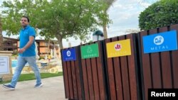 A man walks past recycle bins in Egypt's Red Sea resort of Sharm el-Sheikh town as the city prepares to host the COP27 summit next month, in Sharm el-Sheikh, Egypt Oct. 20, 2022.