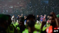 Para suporter terlihat turun ke lapangan setelah pertandingan sepak bola antara Arema FC dan Persebaya di stadion Kanjuruhan di Malang, Jawa Timur. (Foto: AFP)
