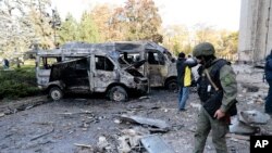 Tim investigasi memeriksa lokasi serangan di dekat gedung pemerintahan di Donetsk, di timur Ukraina, pada 16 Oktober 2022. (Foto: AP/Alexei Alexandrov)
