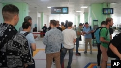 Russian men line up to register at a public service center in Almaty, Kazakhstan, Sept. 27, 2022. After President Vladimir Putin ordered a partial mobilization to bolster his troops in Ukraine, many Russians are leaving their country. (Vladimir Tretyakov//NUR.KZ via AP)