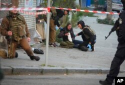 Medics help injured woman after after a drone fired on buildings in Kyiv, Ukraine, Monday, Oct. 17, 2022. (AP Photo/Efrem Lukatsky)