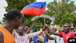 Les nombreux drapeaux russes brandis dans la rue illustrent la question de la lutte d'influence entre l'ancien colon français et la Russie. 