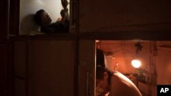 FILE - Residents rest in their "shoebox" apartments, in Hong Kong, March 28, 2017.