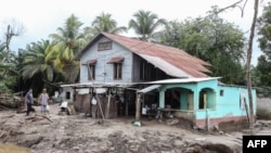 Residents prepare to leave their house at the former banana fields of the municipality of El Progreso, Honduras, before the arrival of Tropical Storm Julia, on Oct. 8, 2022.