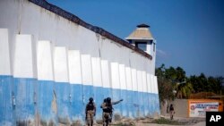 FILE - Police search for escaped inmates on the perimeters of a prison in Port-au-Prince in Haiti, Feb. 25, 2021. On Tuesday, a nonprofit called on Haiti’s government to release certain inmates amid a rise in cholera cases throughout the prison system.