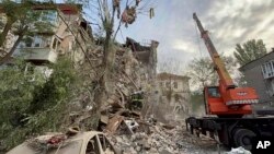 Layanan Darurat Ukraina, tim penyelamat bekerja di lokasi sebuah bangunan yang rusak akibat penembakan di Zaporizhzhia, Ukraina, 6 Oktober 2022. (Foto: via AP)