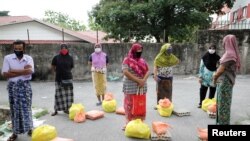 FILE- Rohingya refugees waiting to receive goods from volunteers, during the movement control order due to the outbreak of the coronavirus disease (COVID-19), in Kuala Lumpur, Malaysia, Apr. 7, 2020.