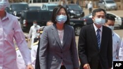 Taiwan's President Tsai Ing-wen, center, walks to take part in a launch ceremony for its first indigenous amphibious transport dock in Kaohsiung, southern Taiwan, April 13, 2021.