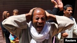 Relatives and families of members of the Muslim Brotherhood react outside a court in Minya, south of Cairo, after the sentences of Brotherhood leader Mohamed Badie and his supporters were announced, June 21, 2014.