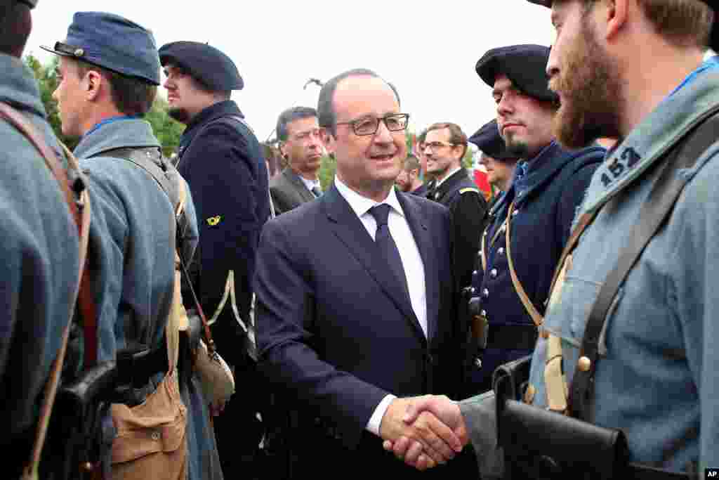 Fransiya prezidenti Fransua Olland Birinchi jahon urushi askarlari formasidagi yevropalik bilan ko&#39;rishayapti. 100 yil muqaddam Germaniya qo&#39;shnilarga hujum qilib, Birinchi jahon urushi boshlangan edi.