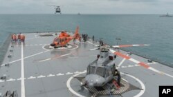 Sebuah helikopter tiba di landasan KRI Banda Aceh, dekat area di mana sebuah tim SAR menemukan ekor pesawat AirAsia QZ 8501 di Laut Jawa, Kamis, (8/1).