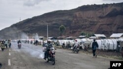 Des personnes déplacées qui ont fui l'avancée de la rébellion du M23 (Mouvement du 23 mars) construisent des huttes le long de la route nationale 2 à Kanyaruchinya, dans le district nord de Goma, le 2 novembre 2022.