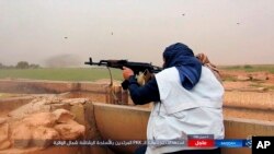 FILE - This undated image posted online Monday, May. 1, 2017, by supporters of the Islamic State militant group on an anonymous photo sharing website, purports to show an Islamic State fighter firing his weapon during clashes with U.S.-backed Kurdish-led Syrian Democratic Forces, in the northern Syrian province of Raqqa.