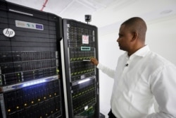 Abubakr Salih Babiker, a climate scientist at the Intergovernmental Authority on Development's Climate Prediction and Applications Center, shows server racks containing a supercomputer in Nairobi, Kenya, March 5, 2020.