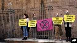 Activists from Extinction Rebellion use bike locks to chain themselves to a fence during a demonstration outside the G-20 summit in Rome, Italy, Oct. 31, 2021. 