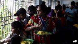 Evacuated Indian villagers watch the storm from a temporary shelter in Chatrapur, India, Oct. 12, 2013.
