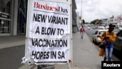 A woman walks past newspaper billboards during the coronavirus disease (COVID-19) outbreak in Johannesburg, South Africa, February 8, 2021. 