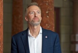 FILE - In this Aug. 5, 2019, file photo, Mayor Ted Wheeler stands outside City Hall in Portland, Oregon.