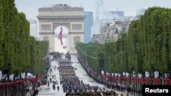 Troops walk down the Champs-Elysees avenue during the Bastille Day parade in Paris, France, July 14, 2021.