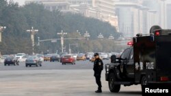 A Chinese policeman of the Special Weapons and Tactics (SWAT) team stands guard on a main street next to Tiananmen Square in Beijing, Oct. 31, 2013.