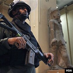 Seorang anggota pasukan keamanan menjaga sebuah museum di Kairo. PBB mengecam penggunaan kekerasan terhadap para demonstran.