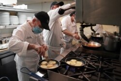 Chef Eksekutif Vito Gnazzo dari restoran Il Gattopardo menyiapkan hidangan pembuka mozzarella asap pada hari pertama restoran diizinkan untuk mulai bersantap di dalam ruangan sejak Covid-19 di Manhattan Borough of New York City, New York, AS, 30 September