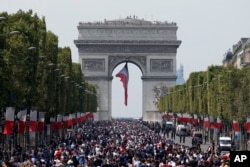 The crowd gathers to welcome the French soccer team for a parade a day after the French team victory in the soccer World Cup, July 16, 2018 in Paris.