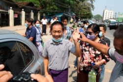 AP journalist Thein Zaw, center, waves outside Insein prison after his release, March 24, 2021 in Yangon, Myanmar.