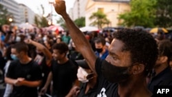 Para pengunjuk rasa berdemo di tengah hujan badai di depan Lafayette Park, di samping Gedung Putih, Washington D.C., 5 Juni 2020.
