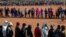 FILE - People affected by the coronavirus economic downturn line up to receive food aid in Pretoria, South Africa, May 20, 2020.