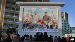 FILE - North Koreans gather in front of a portrait of their late leader Kim Il Sung, left, and Kim Jong Il, right, paying respects to their late leader Kim Jong Il, to mark the third anniversary of his death.