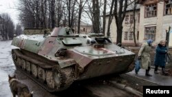 ស្រ្តី​ម្នាក់​ដើរ​កាត់​រថក្រោះ​របស់​កងទ័ព​អ៊ុយក្រែន​ដែល​ត្រូវ​បាន​បំផ្លាញ​ នៅ​ក្នុង​ទីក្រុង​ Debaltseve ស្ថិត​នៅ​ភាគ​ខាង​ជើង​ឆៀង​ខាង​កើត​ក្រុង​ Donetsk កាល​ពី​ថ្ងៃ​ទី​១៣​ ខែ​មីនា​ ឆ្នាំ​២០១៥។