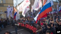 Demonstrators carry portraits of slain opposition leader Boris Nemtsov and a big poster reading "Killed for Freedom" during a march marking the one-year anniversary of his killing, in Moscow, Russia, Feb. 27, 2016.